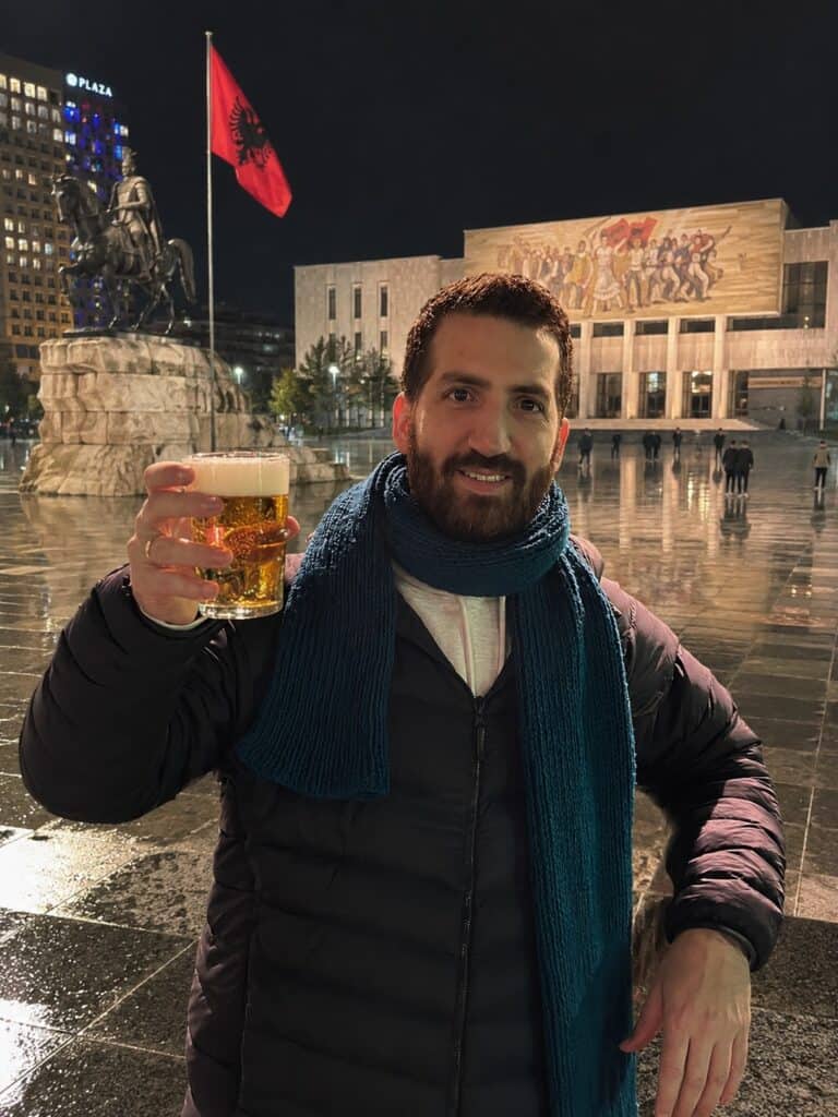 לירון המומחה לטירנה שותה בירה מקומית בכיכר המרכזית של טירנה